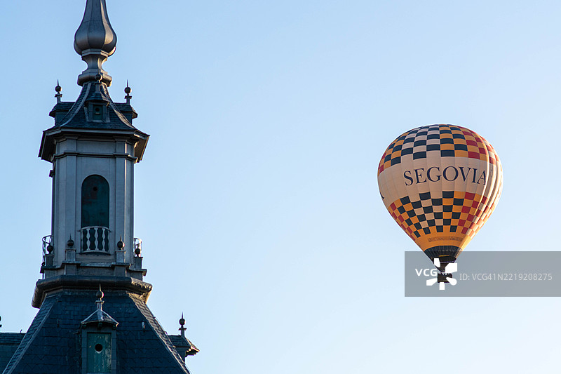 热气球在西班牙塞哥维亚的塔楼附近漂浮图片素材