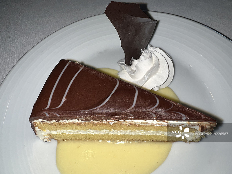 黄蛋糕切片，配巧克力糖霜和香草奶油酱图片素材