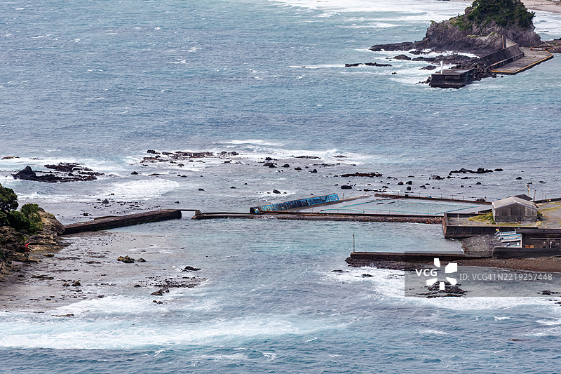 从悬崖俯瞰下来的下田白浜海滩。前景是龙宫岛和白岛神社。油轮和其他船只在海上航行。图片素材