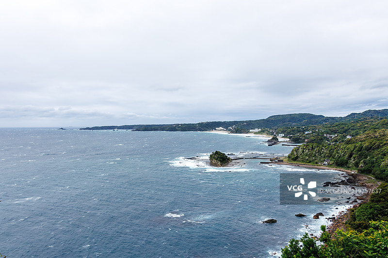 从悬崖俯瞰下来的下田白浜海滩。前景是龙宫岛和白岛神社。油轮和其他船只在海上航行。图片素材