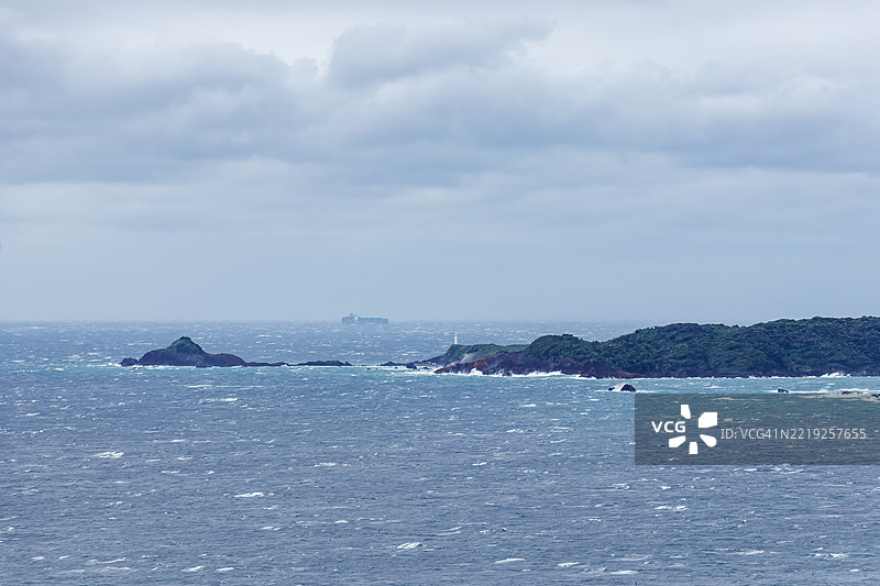 从悬崖俯瞰下来的下田白浜海滩。前景是龙宫岛和白岛神社。油轮和其他船只在海上航行。图片素材