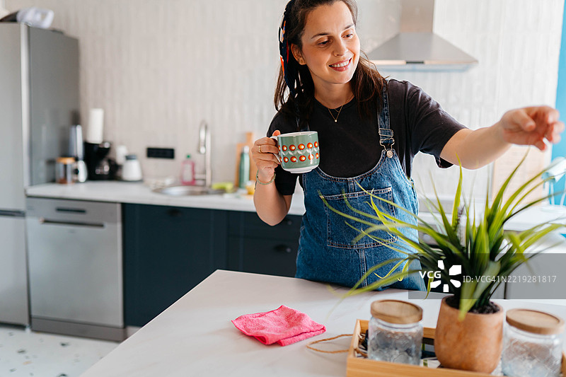 美丽的孕妇在家中照顾她的植物图片素材