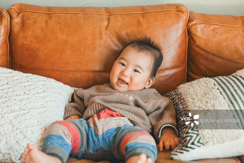 坐在沙发上的可爱亚洲宝宝肖像图片素材