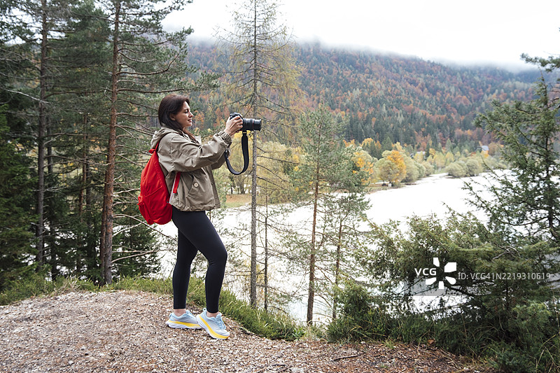 一位年轻女性捕捉到山间河流的美丽图片素材