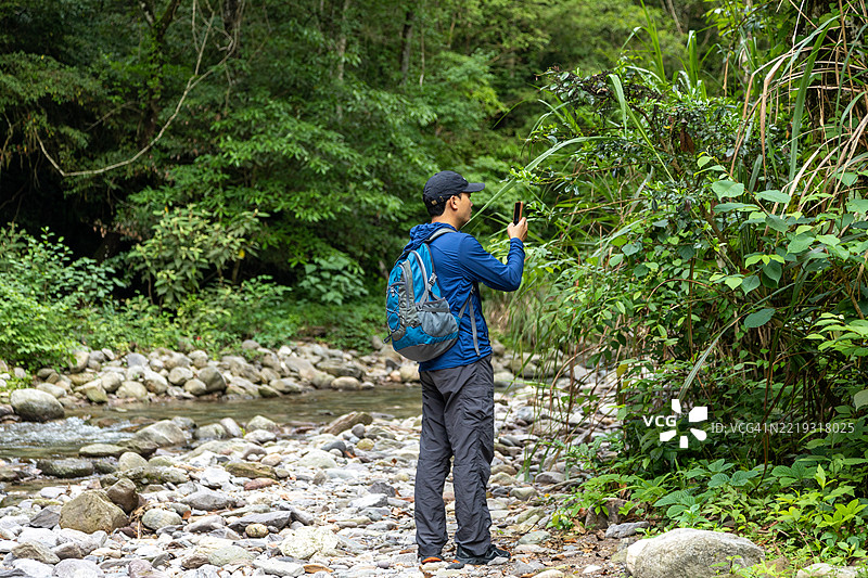 男子在溪流中徒步旅行图片素材