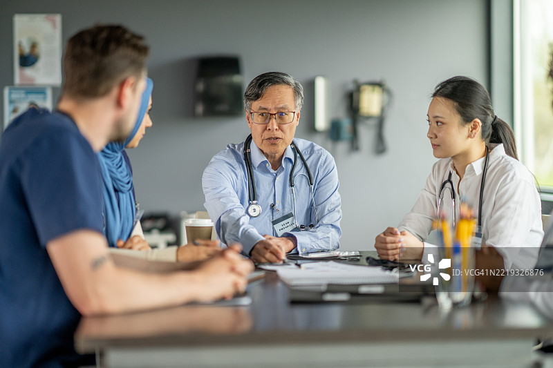 医疗专业人士在团队会议中合作讨论病人护理图片素材