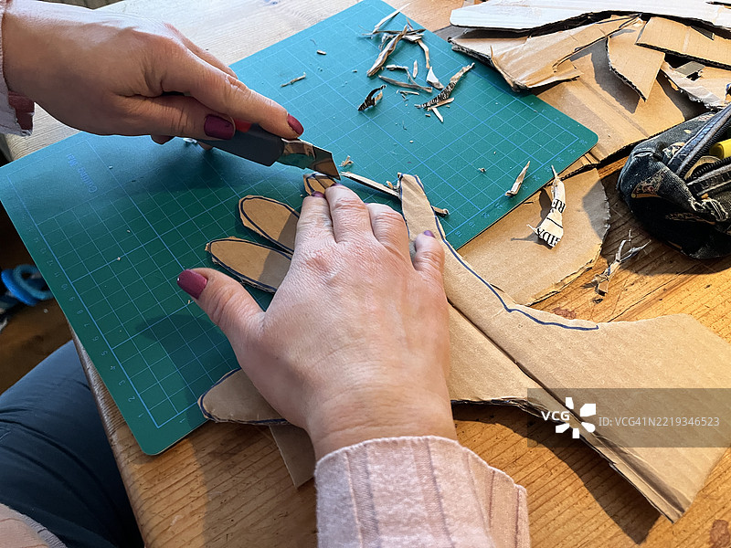 欧洲的拉丁美洲圣诞和新年传统 - 一名女性在荷兰剪纸板制作“旧年”（año viejo）以迎接新年夜图片素材