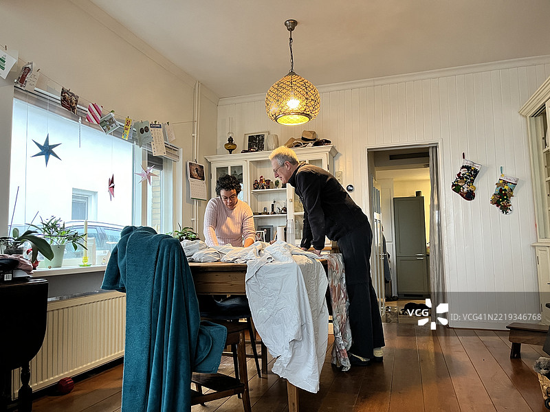 在圣诞节期间，荷兰的一对情侣正在准备“旧年”人偶，庆祝拉丁美洲的圣诞和新年传统。图片素材