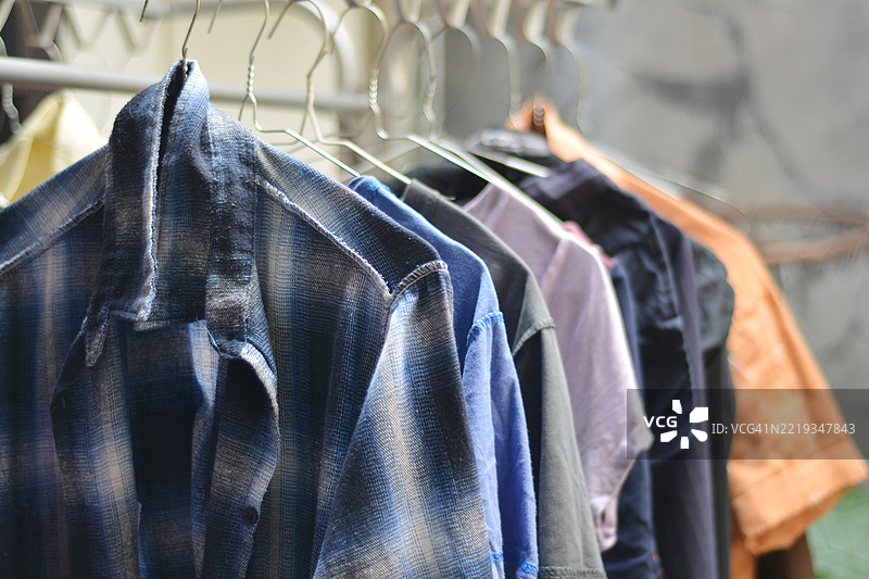 蓝白格子衬衫和其他彩色衣物挂在户外晾干图片素材