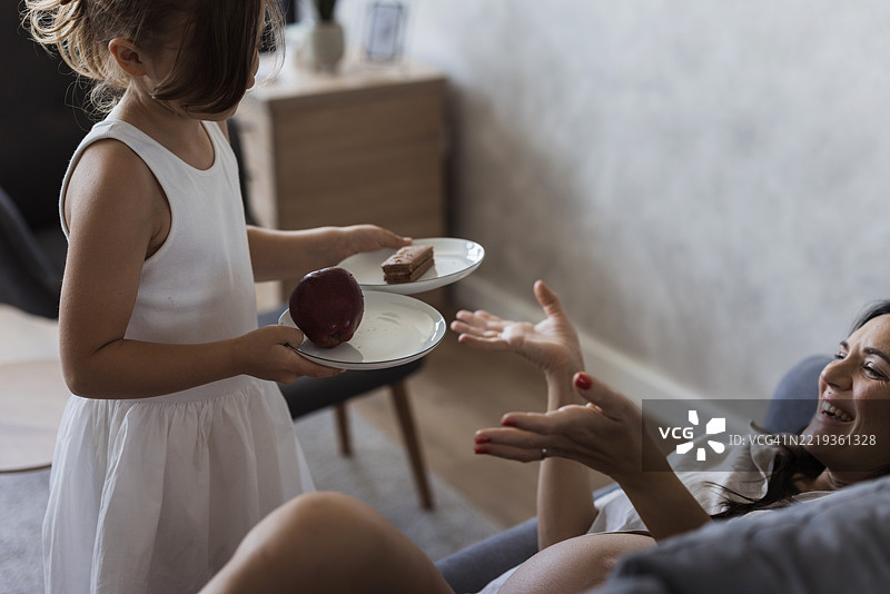 孕妇在选择苹果或蛋糕作为零食图片素材
