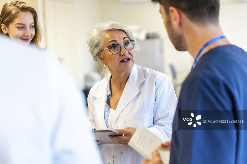 资深女医生在医院会议上向医务人员简报，讨论病人护理策略并与团队分享她的专业知识。图片素材