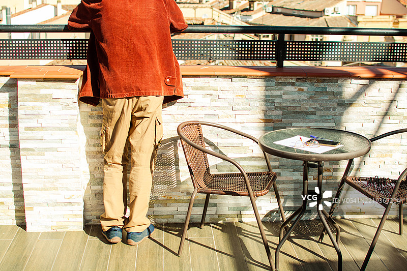 成熟男性从阳台上俯瞰城市景观图片素材