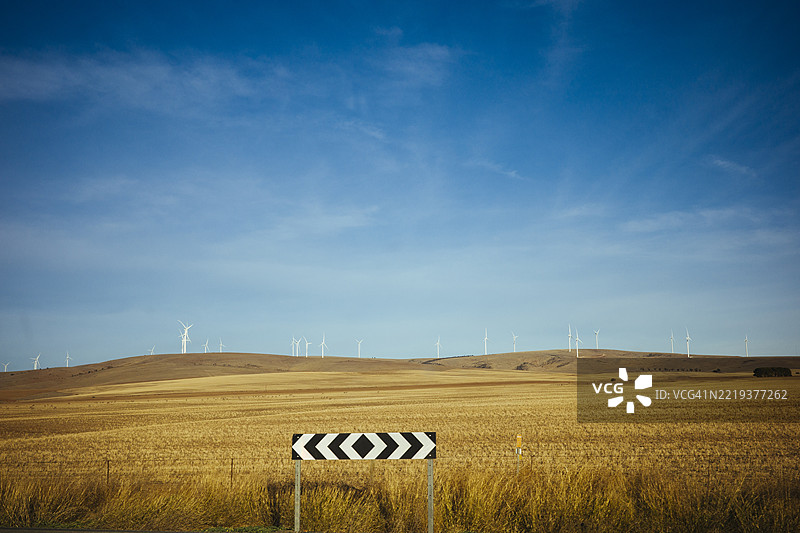 乡村田野中的风车与蓝天背景图片素材