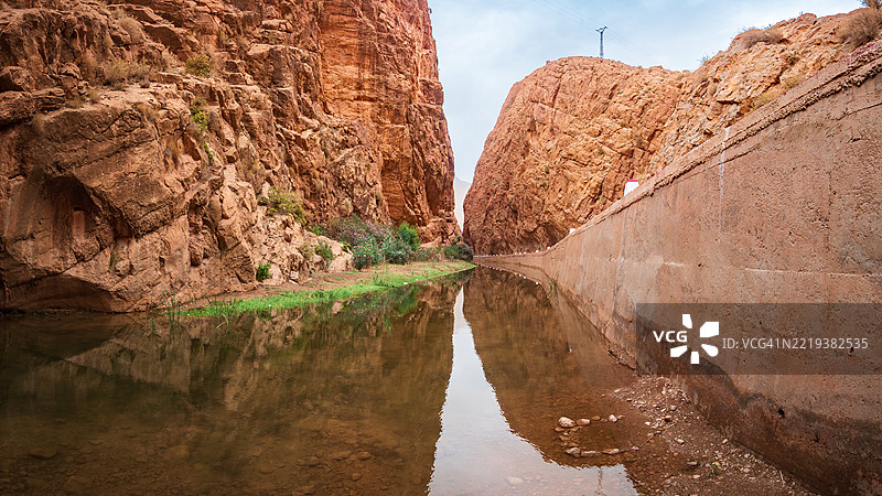 达德斯河峡谷的景观，岩壁和峡谷在水中倒影，右侧是空旷的主干道，布马尔内达德斯（Boumalne-Dadès） - 提内里省 - 德拉-塔菲拉勒 - 阿特拉斯山脉 - 摩洛哥。图片素材