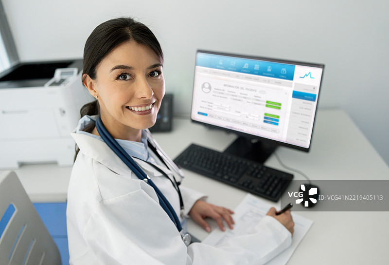 快乐的医生在办公室工作并微笑图片素材