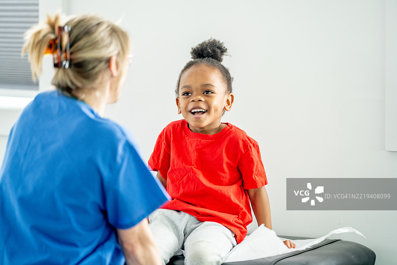 快乐的孩子在临床环境中看医生图片素材