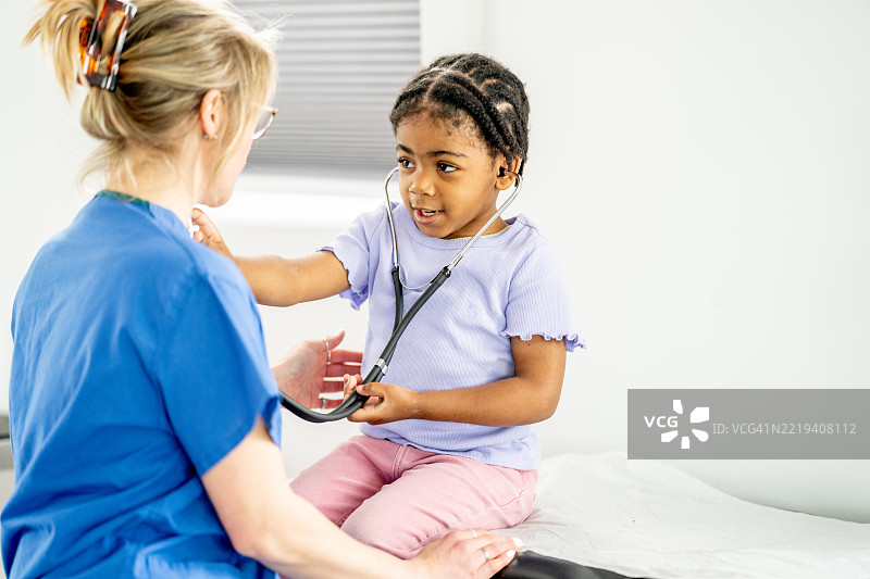 孩子与护士使用听诊器互动，学习健康护理知识图片素材