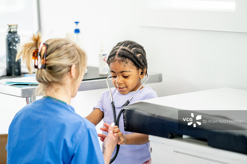 护士与小女孩在诊所进行有趣的体检图片素材
