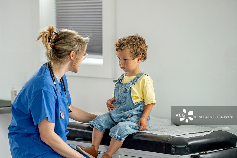 孩子在诊所接受关心护士的医疗咨询图片素材