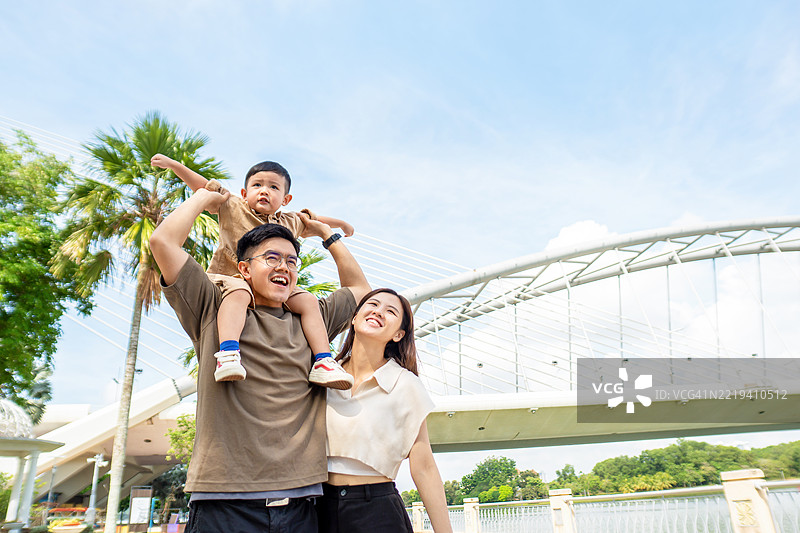 父母在散步时给儿子骑背。图片素材