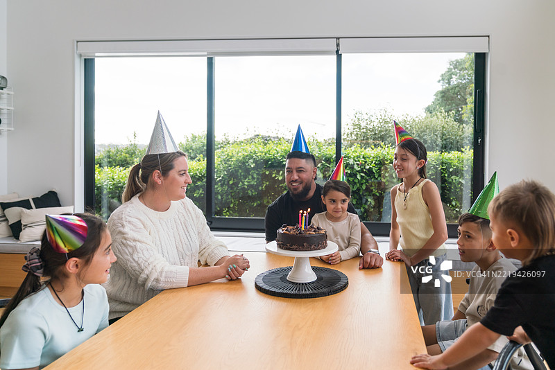 为生日庆祝做好准备，家人在蛋糕前团聚。图片素材