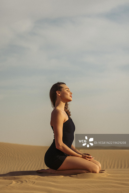 女人在宁静的日子里于沙漠中户外练习冥想图片素材
