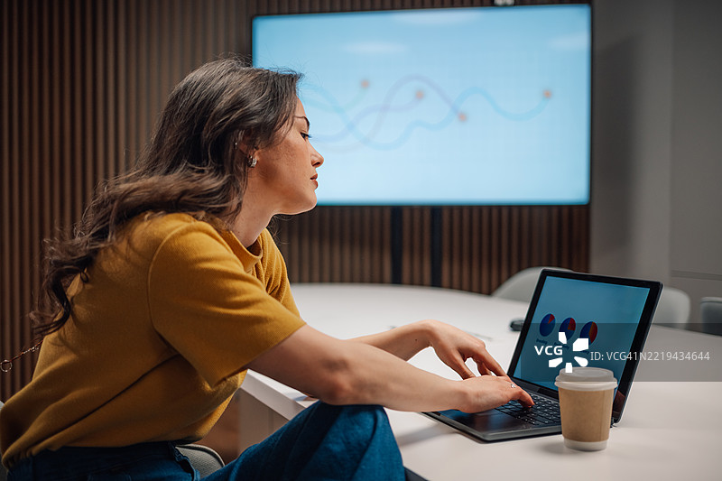 专注的女商人在现代办公室使用笔记本电脑分析市场数据图片素材