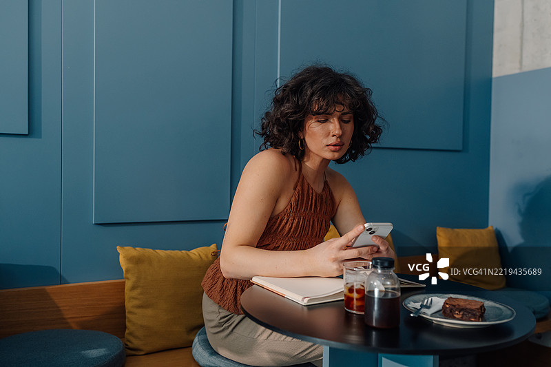 年轻女性在现代咖啡店使用手机图片素材