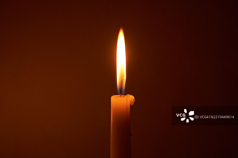 黑暗环境中散发温暖光芒的蜡烛图片素材