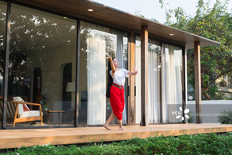 一个小女孩在家练习泰国传统舞蹈。图片素材