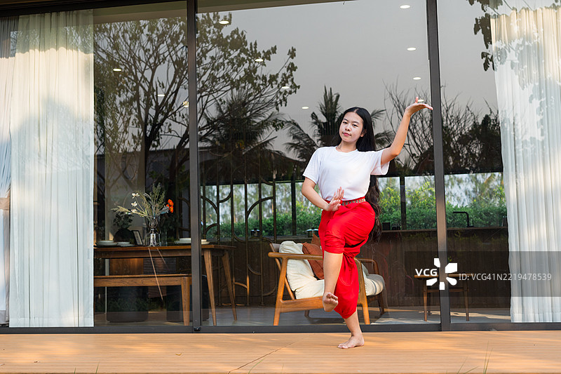 一个小女孩在家里练习泰国传统舞蹈。图片素材