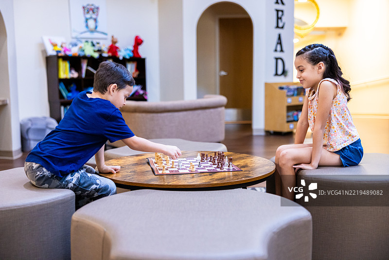 小学学生在图书馆下棋图片素材