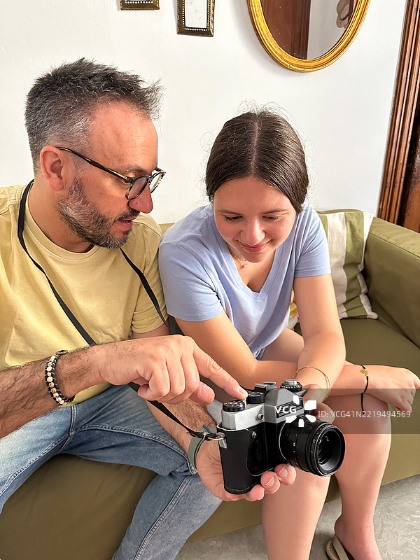 父亲教女儿如何使用一台老式复古相机图片素材