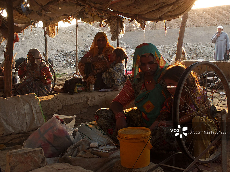 路边摊旁的铁匠与家人一起工作图片素材