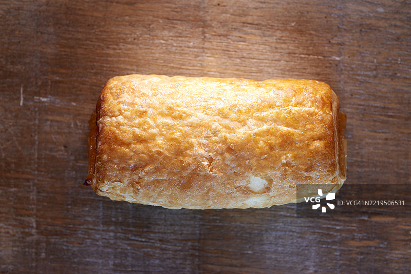 新鲜出炉的金黄色泡芙酥皮放在木质表面上图片素材
