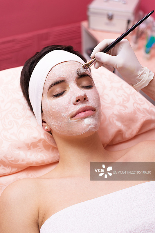 年轻女性在美容SPA中接受面膜护理图片素材