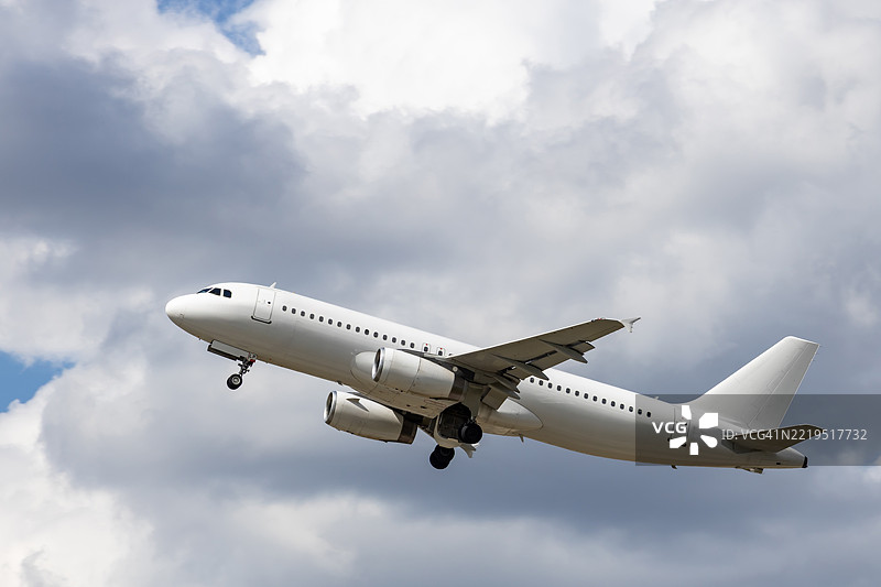 白色客运飞机在阴云密布的天空中图片素材