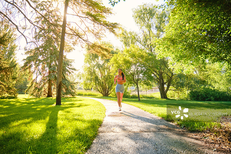 年轻女性在夏季早晨的公园里锻炼图片素材