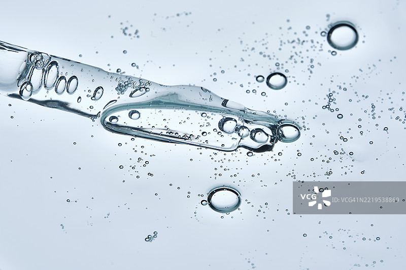 从下方拍摄的精华液或化妆凝胶的质地，带有滴管图片素材