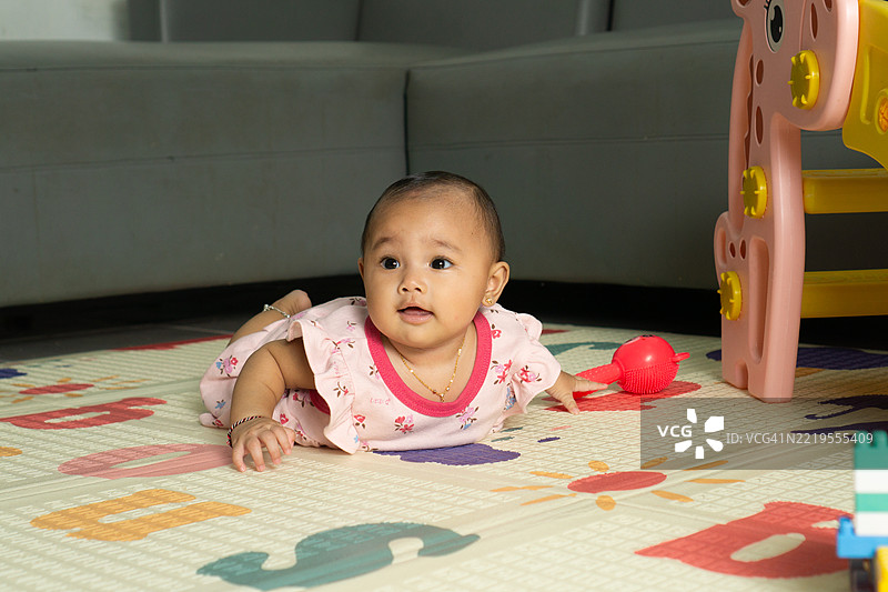 婴儿躺在游戏垫上图片素材