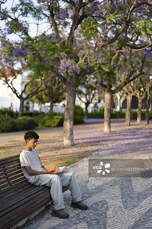 春天在塞图巴尔阅读书籍的少年男孩图片素材