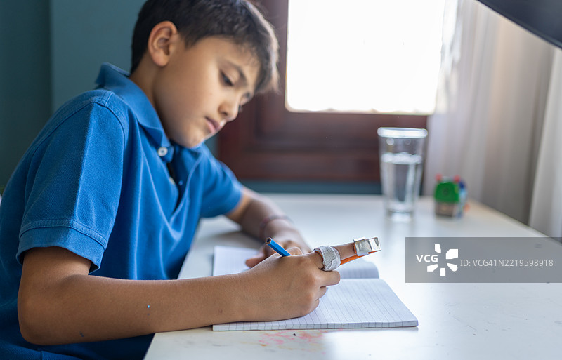 受伤男孩的手指被夹板固定图片素材