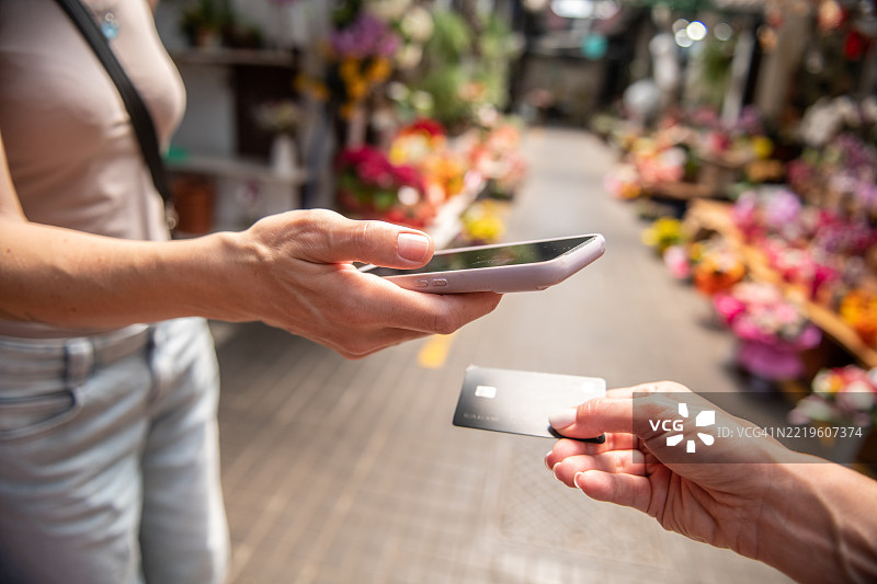女性在市场上进行无接触支付图片素材