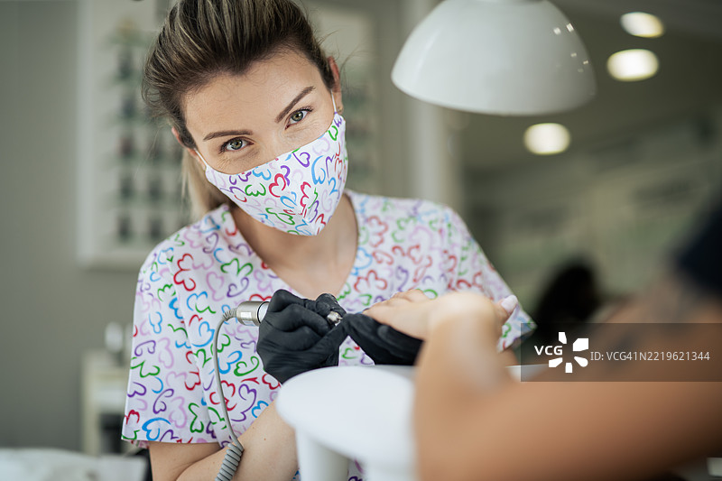 美甲师在工作时看着镜头的肖像。图片素材