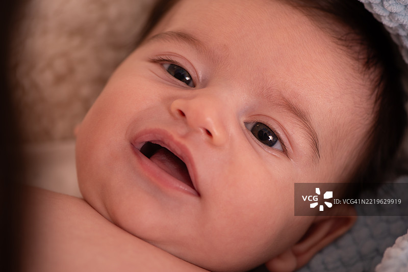 微笑的宝宝，明亮的眼睛和张开的嘴巴。图片素材
