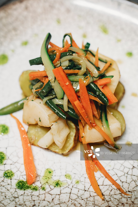 美味的海鲜菜肴，配有土豆、胡萝卜、 zucchini 和青豆图片素材