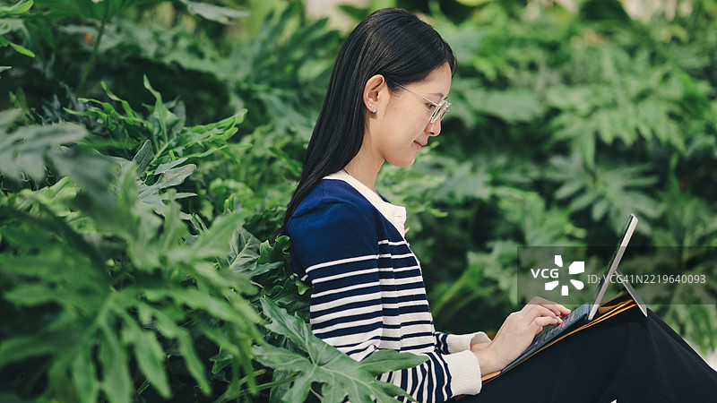 Z世代利用6G技术在线学习，使用智能数字平板计算财务数据进行数字投资。图片素材