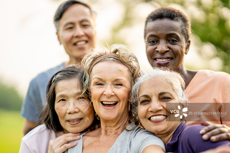 一群多元化的老年朋友在公园里微笑着聚在一起图片素材