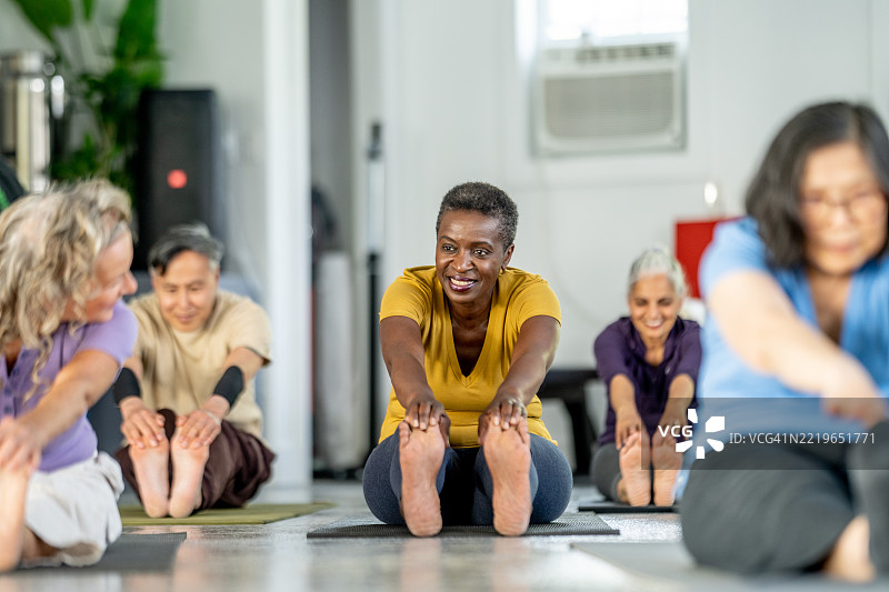 老年人团体在放松的瑜伽室环境中一起练习瑜伽图片素材