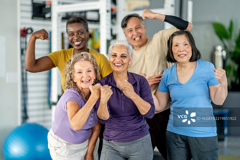一群积极的老年人在健身环境中拥抱健身并微笑图片素材